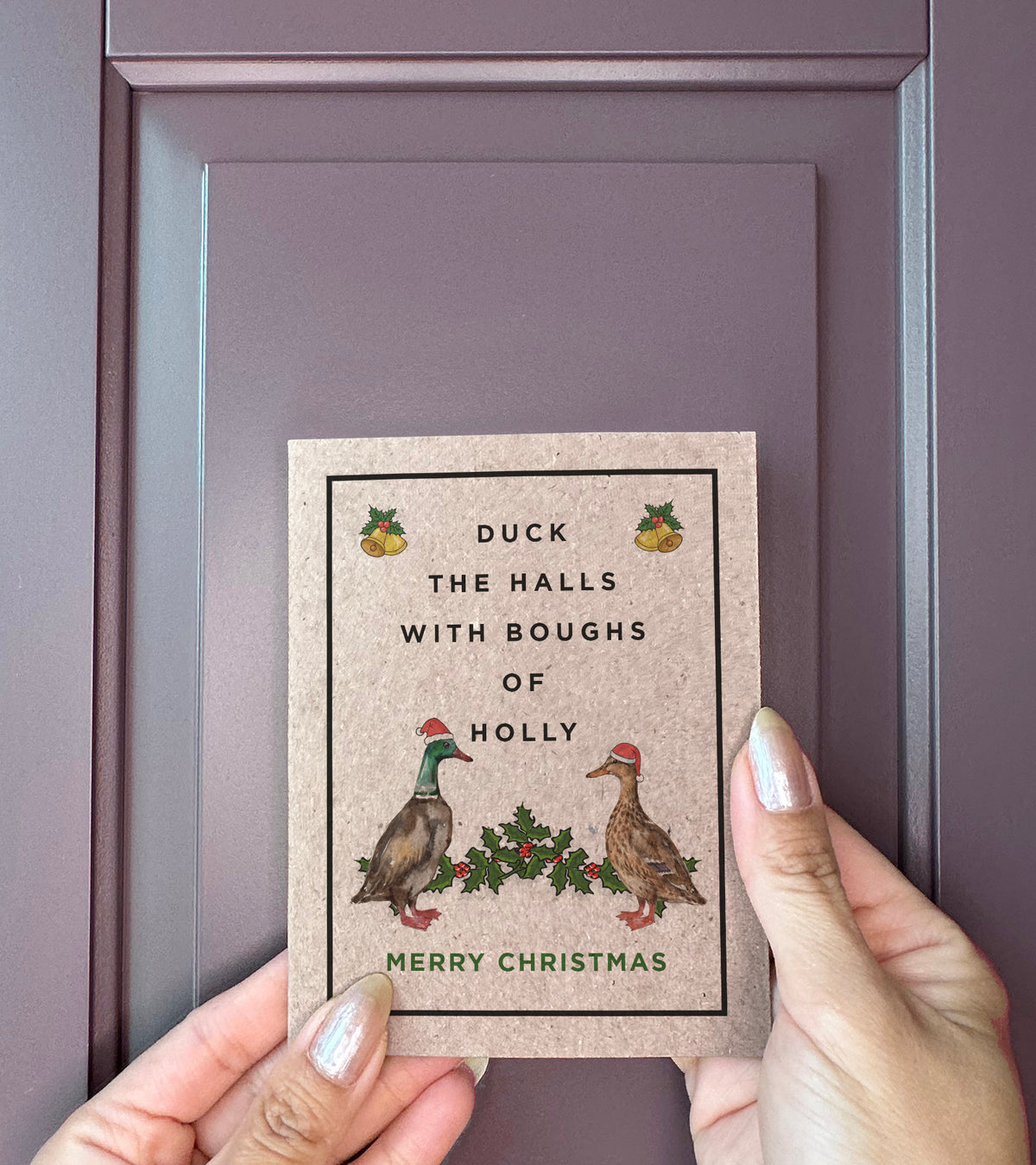 Duck the Halls Christmas card held in hand